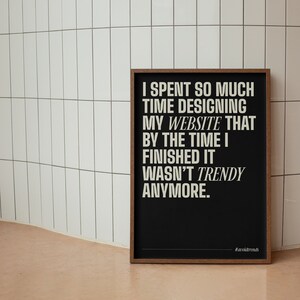 May include: A black framed poster with white text that reads "I spent so much time designing my website that by the time I finished it wasn't trendy anymore." The poster has the hashtag #avoldtrends at the bottom.