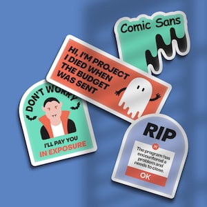 May include: A collection of humorous stickers with a Halloween theme. Designs include a vampire, a ghost, a tombstone with "RIP", and text that reads "Comic Sans". The stickers are on a blue background.