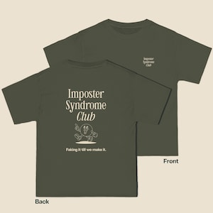 K&ouml;nnte beinhalten: Ein gr&uuml;nes T-Shirt mit dem Text "Imposter Syndrome Club" und einer Comicfigur auf der R&uuml;ckseite. Die Vorderseite des Shirts tr&auml;gt den Text "Imposter Syndrome Club" in kleinerer Schrift.
