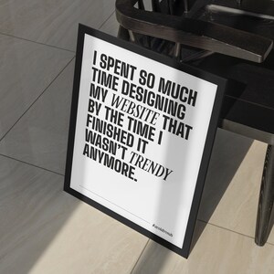 May include: Black and white framed print with the text "I spent so much time designing my website that by the time I finished it wasn't trendy anymore." The text is in bold and the hashtag #avoldtrends is at the bottom of the print.