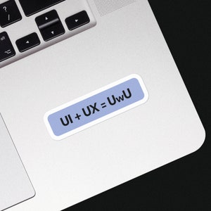 Könnte beinhalten: Ein hellblauer Aufkleber mit weißem Rand auf einem silbernen Laptop. Der Aufkleber trägt den Text "UI + UX = UwU" in Schwarz.