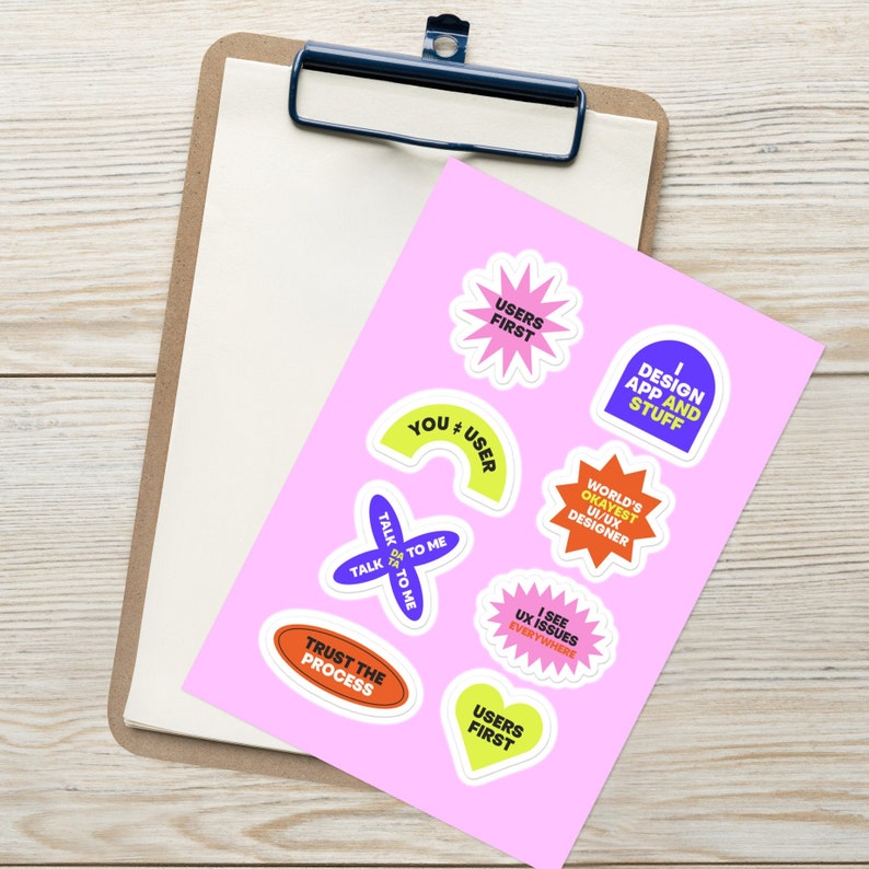 May include: A set of nine colorful stickers with various phrases related to user experience design. The stickers feature phrases like "Users First", "I Design App and Stuff", "World's Okayest UI/UX Designer", "Talk to Me", "Trust the Process", "I See UX Issues Everywhere", and "You + User".