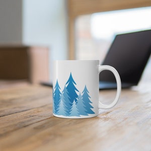 Pine tree forest silhouette coffee mug with minimalist blue fir and evergreen tree design printed on a BPA free and Lead Free 11 oz coffee Mug, ideal gift for the nature lover