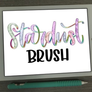May include: A white tablet screen displaying the text "Stardust Brush" in a rainbow glitter font. The text is on a white background.