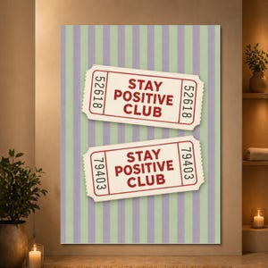 May include: A rectangular wall art print featuring two off-white admission tickets with red borders and red text that reads STAY POSITIVE CLUB. The tickets have unique serial numbers and are set against a background of vertical light green and purple stripes.