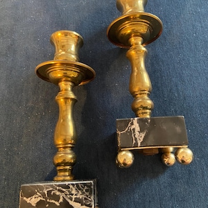 Pair of marble and brass candlestick holders. Measures 7” tall x 2” wide. Unique and pretty!