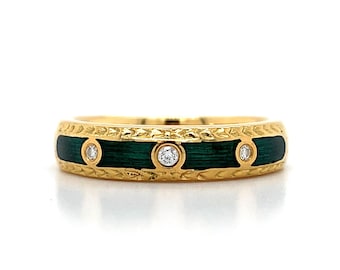 Puede incluir: Un anillo de banda de oro con una incrustación de esmalte verde y tres pequeños diamantes.