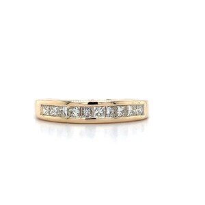 May include: A gold band with a row of small, square-shaped diamonds set in a channel setting.