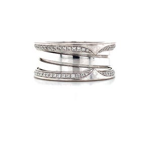 May include: A silver ring with multiple bands. The top and bottom bands are adorned with small, clear gemstones. The ring has a unique design with decorative elements on the sides, creating a layered appearance. The ring is set against a white background.