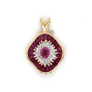 May include: A gold pendant featuring a central oval-cut pinkish-red gemstone surrounded by a halo of small white stones. An outer border of baguette-cut deep red rubies frames the design, which is finished with a gold bail at the top.