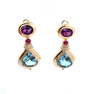 May include: A pair of gold drop earrings featuring an oval purple amethyst at the top, a small round red ruby in the centre, and a large pear-shaped light blue topaz at the bottom, accented with a row of tiny clear white diamonds.