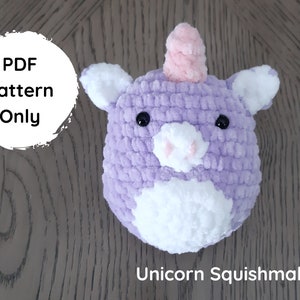 May include: A handmade, plush unicorn head in shades of lavender, white, and pink. The unicorn has black button eyes and a white muzzle. The text "PDF Pattern Only" is in a white circle. The text "Unicorn Squishmallow" is below the unicorn.