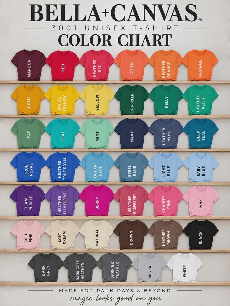 May include: A Bella+Canvas 3001 unisex t-shirt color chart displaying 42 short-sleeve shirts in various colors arranged on wooden shelves. Each shirt is labeled with its specific color name, including maroon, red, orange, yellow, green, blue, purple, pink, brown, gray, black, and white.