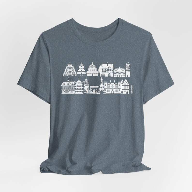 May include: A heathered slate blue short-sleeve t-shirt featuring a white graphic print of two rows of various international architectural landmarks, including towers, pagodas, and historic buildings arranged in a horizontal skyline pattern.
