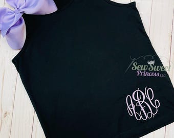 Peut inclure: Débardeur noir avec un monogramme brodé violet clair et un grand nœud violet clair. Le débardeur a un col rond et est fait d'une matière douce. Le texte "Sew Sweet Princess LLC" est également visible.