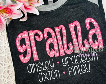 Peut inclure: Un t-shirt gris foncé avec le mot "granna" en rose avec un motif géométrique blanc et rose. Sous le mot "granna" se trouvent les noms Ainsley, Gracelyn, Axton et Finley en blanc.
