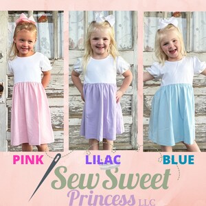 May include: Three girls wearing white-top dresses with different colored skirts: pink, lilac, and blue. Each girl has a matching bow in her hair. The text "PINK", "LILAC", and "BLUE" are below each girl. The text "Sew Sweet Princess LLC" is also visible.