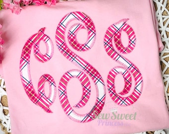 Peut inclure: Un t-shirt rose clair avec un motif de monogramme. Le monogramme est dans une police script et rempli d'un motif à carreaux rose, blanc et marine. Le t-shirt porte le texte "Sew Sweet Princess" dans le coin inférieur droit.