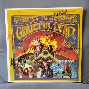 May include: Vintage Grateful Dead album cover with band members' signatures. The album art features a colorful psychedelic design with the band's name in large letters. The cover is yellow and has the Warner Bros. Records logo.