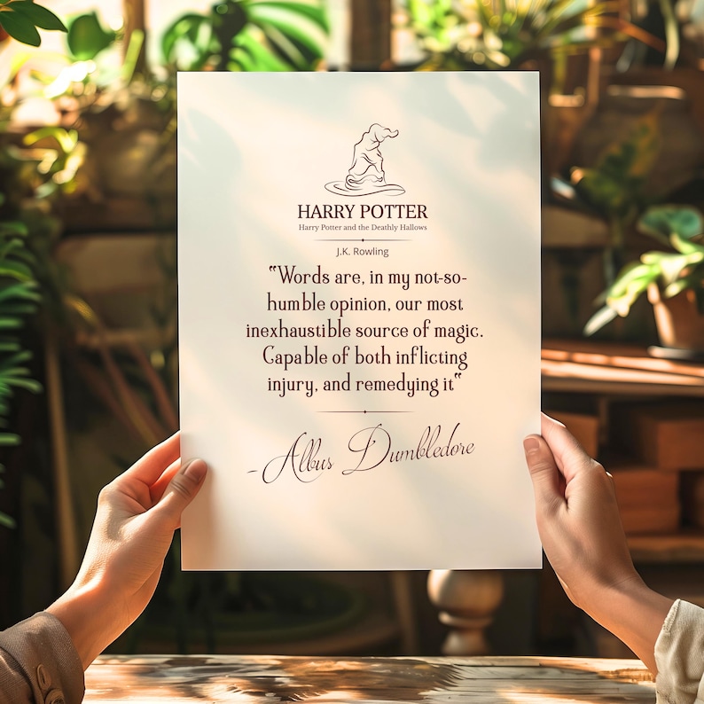 May include: A printed quote from Harry Potter on white paper. The text includes a quote by Albus Dumbledore, the Harry Potter logo, and the author's name, J.K. Rowling. The paper is held up in front of a blurred background.