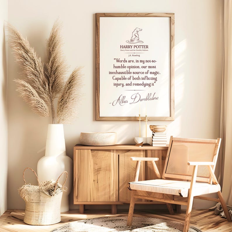 May include: A framed print featuring a quote from Harry Potter, in a light wood frame. The room includes a white vase with pampas grass, a wooden cabinet, a woven basket, and a wooden chair. The print features the Harry Potter logo and a quote by Albus Dumbledore.