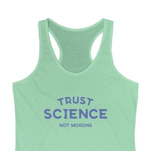 May include: A light green racerback tank top with the text "TRUST SCIENCE NOT MORONS" in blue.