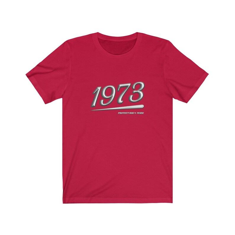 May include: Red short-sleeved t-shirt with a silver graphic of the year 1973 and the text "Protect Roe v. Wade".