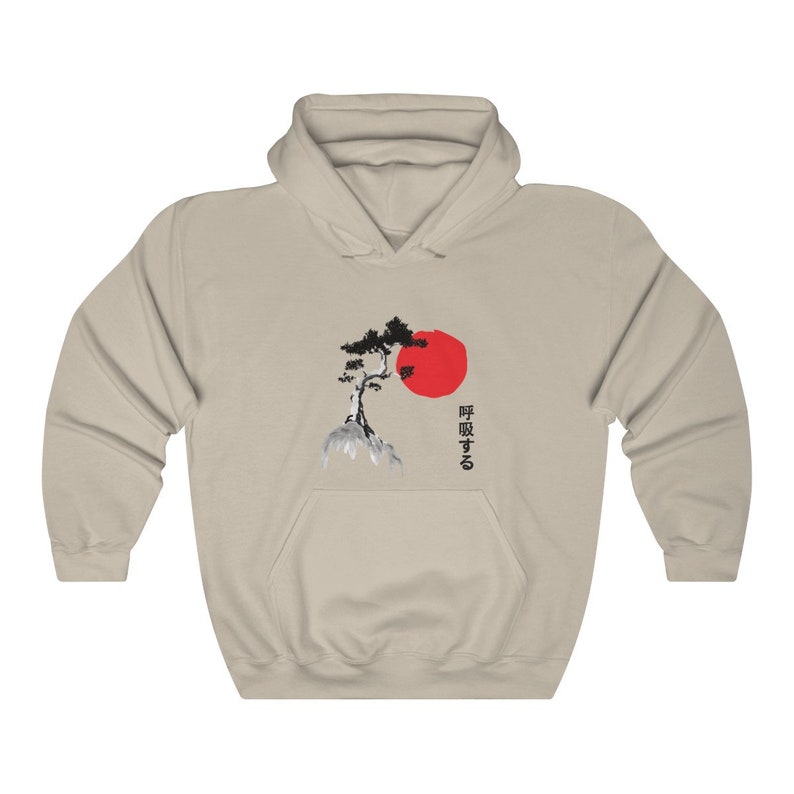 May include: A beige hoodie with a black and white illustration of a pine tree and a red sun. The Japanese text "呼吸する" is printed on the right side of the image.