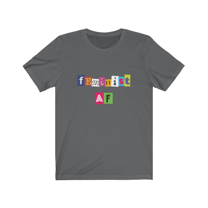 May include: A dark gray t-shirt with the text "feminist AF" printed on it in colorful letters.