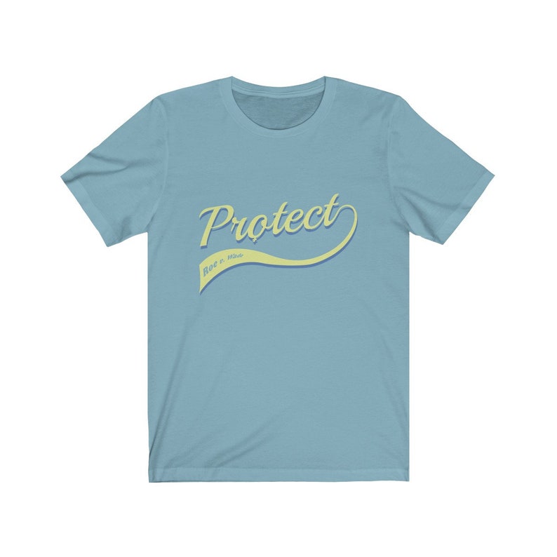 May include: A light blue t-shirt with a yellow curved graphic that says "Protect" with the words "Roe v. Wade" in smaller text underneath.