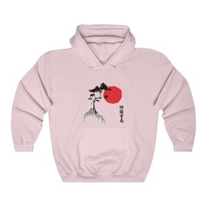 May include: Pink hooded sweatshirt with a black and white illustration of a tree on a rock with a red sun behind it. The Japanese text "呼吸する" is printed on the right side of the image.
