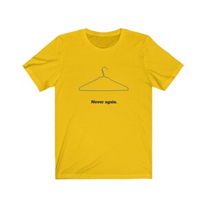 May include: A yellow t-shirt with a black outline of a wire hanger and the text "Never again."