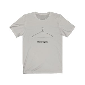 May include: A light gray t-shirt with a black wire hanger graphic and the text "Never again."