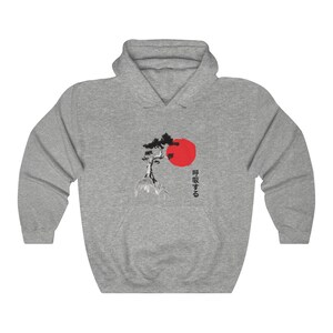 May include: A gray hooded sweatshirt with a black and white image of a pine tree and a red sun. The Japanese text "呼吸する" is printed on the right side of the image.