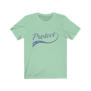 May include: A light green t-shirt with a blue and yellow graphic that says "Protect Roe v. Wade" in a retro-style font.