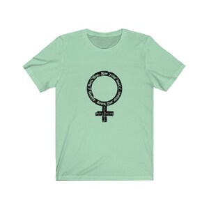 May include: A light green t-shirt with a black graphic of a female symbol. The graphic has the text "Row, Row, Row your boat gently down the stream" around the symbol.