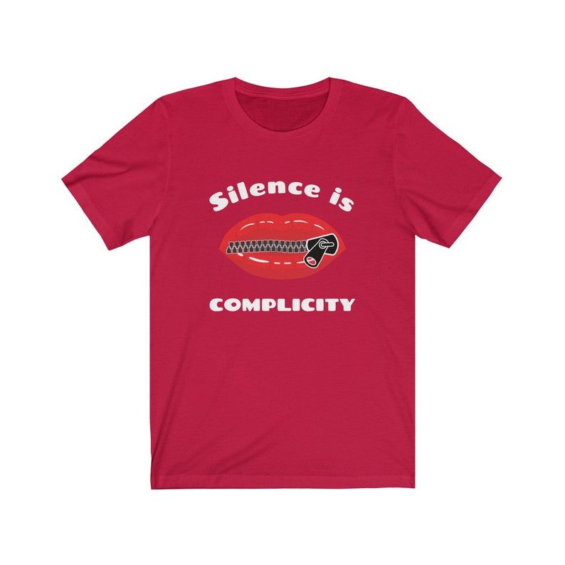 Puede incluir: Camiseta roja con un gr&aacute;fico blanco de una boca con cremallera y el texto "Silence is Complicity".