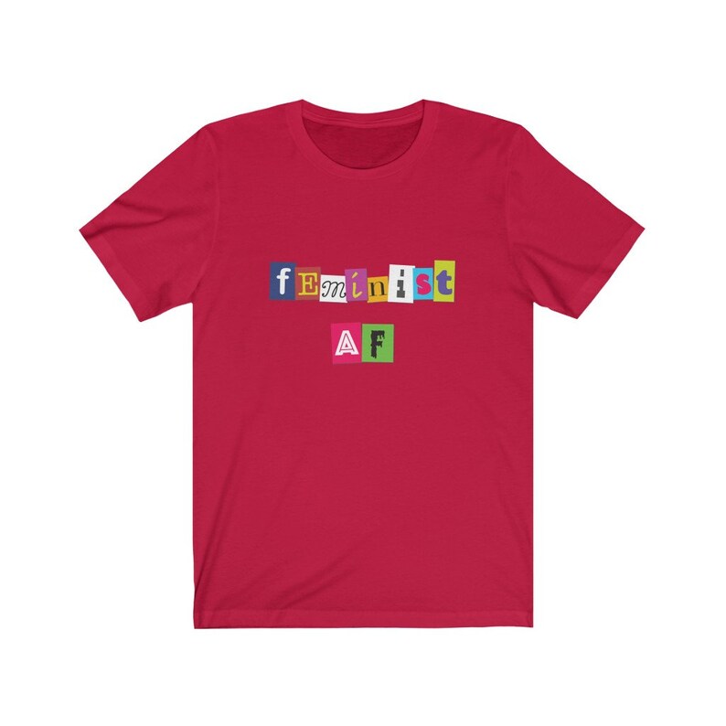 May include: Red short-sleeved t-shirt with the text "feminist AF" in colorful, cut-out letters.