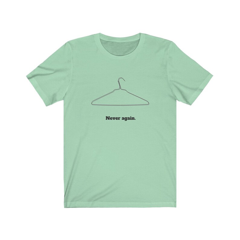 May include: A light green t-shirt with a black wire hanger and the text "Never again." printed on the front.