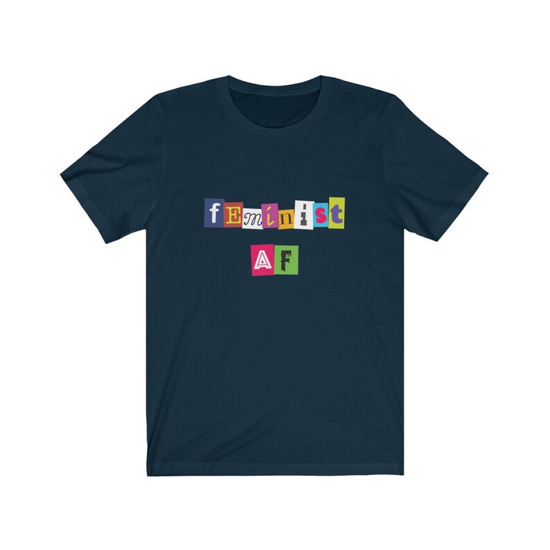 May include: A navy blue t-shirt with the text "feminist AF" in colorful, cut-out letters.
