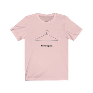 May include: A pink t-shirt with a black wire hanger and the text "Never again."
