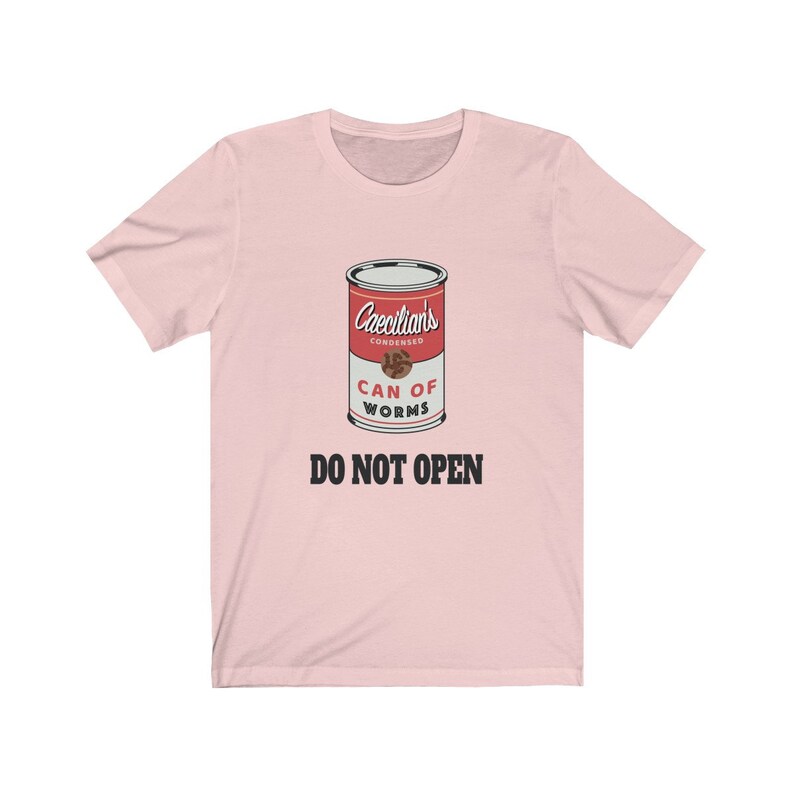 Puede incluir: Camiseta rosa con un gr&aacute;fico de una lata roja etiquetada "Caecilians Condensed Can of Worms" con el texto "Do Not Open" debajo de la lata.