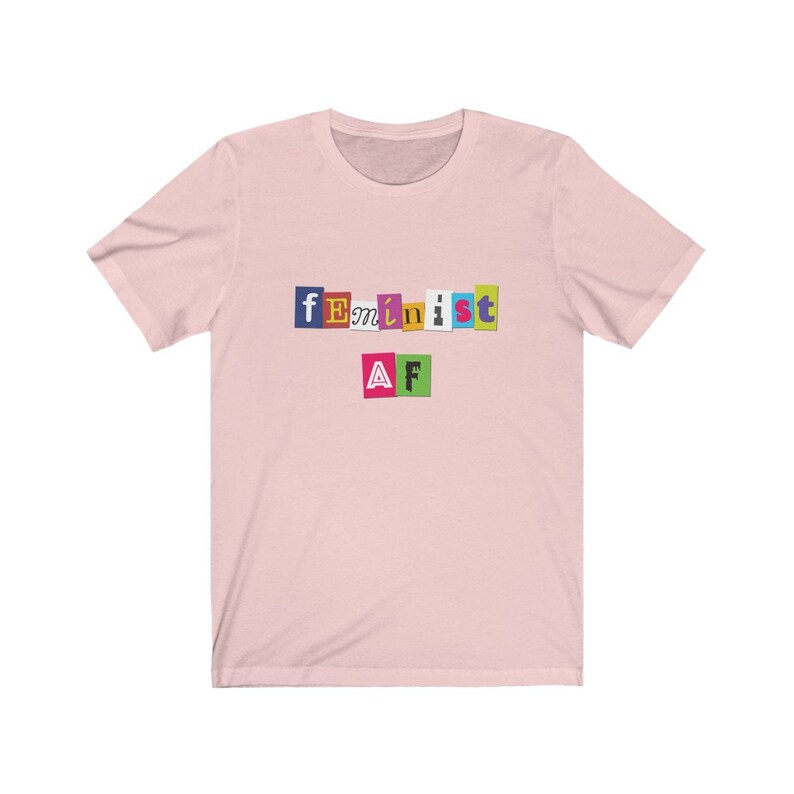 May include: Pink t-shirt with the text "feminist AF" in colorful, cut-out letters.