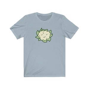 May include: A light blue t-shirt with a cartoon image of a white cauliflower with green leaves.