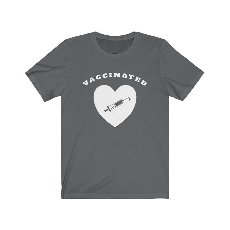 May include: A dark gray t-shirt with the text "VACCINATED" in white letters above a white heart with a syringe inside.