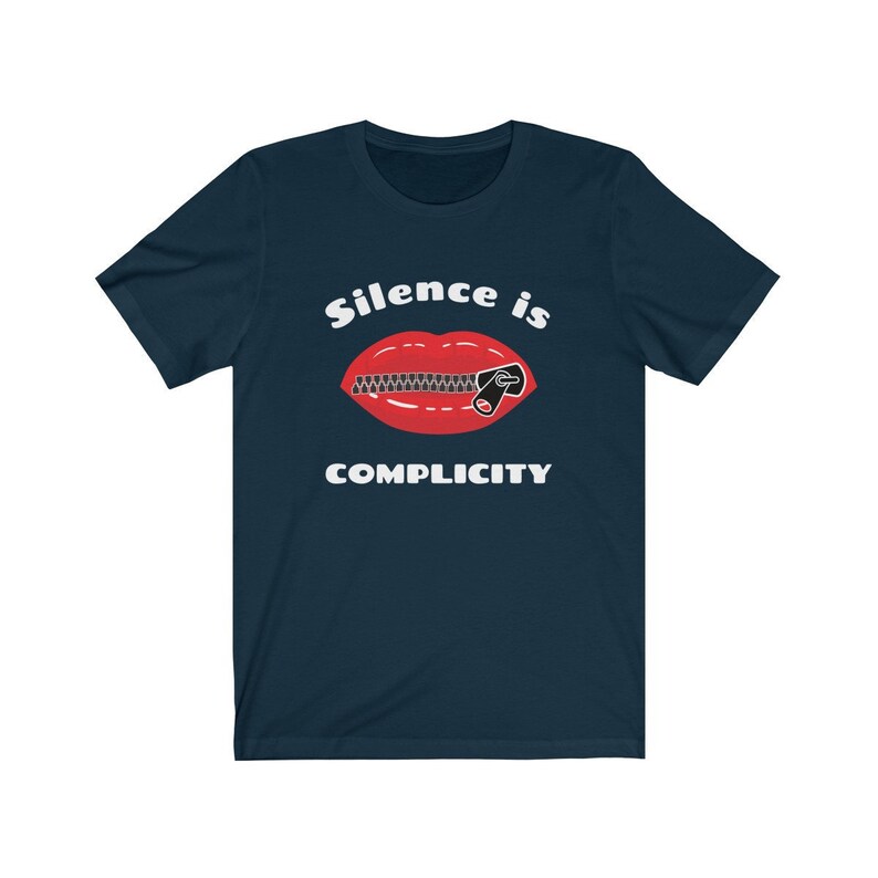 Puede incluir: Una camiseta azul marino con el texto "Silence is Complicity" en blanco. Debajo del texto se muestra una boca roja con una cremallera subida.