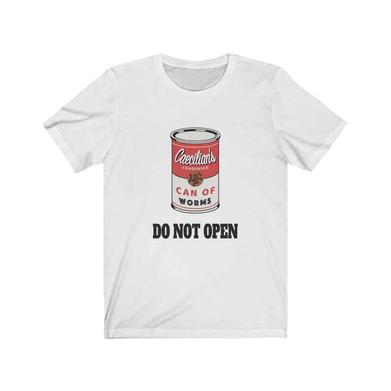 Puede incluir: Camiseta blanca con un gr&aacute;fico de una lata roja etiquetada "Caecilians Condensed Can of Worms" con el texto "DO NOT OPEN" debajo.