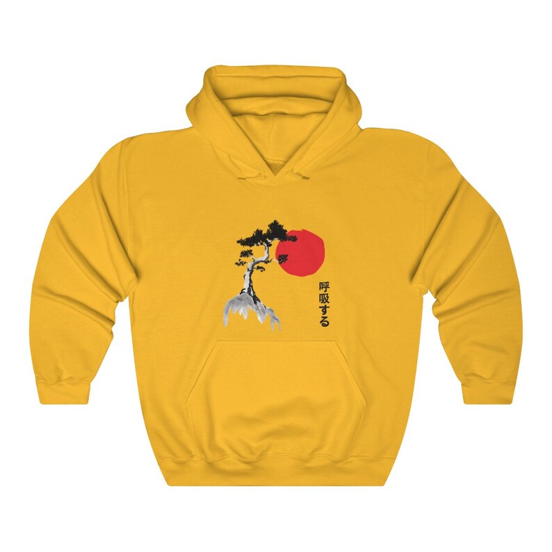 May include: Yellow hoodie with a black and white image of a tree and a red sun. The text "呼吸する" is printed in black below the image.
