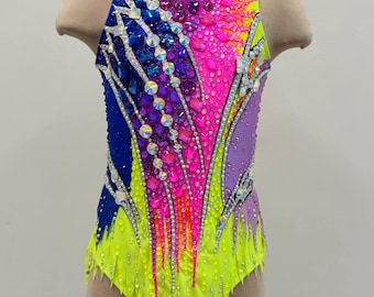May include: A vibrant, decorated leotard for gymnastics or dance. The sleeveless garment features a color gradient from blue to yellow, with pink and purple accents. Embellished with rhinestones and crystals, the leotard has a high neckline and a cut-out leg design.
