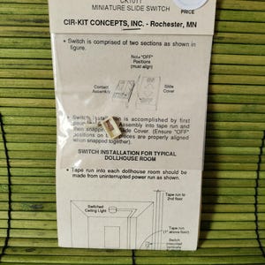 May include: A miniature slide switch for dollhouse rooms, packaged in a clear plastic bag. The package includes instructions and diagrams for installation. The text on the package reads "CIR-KIT CONCEPTS, INC. - Rochester, MN".
